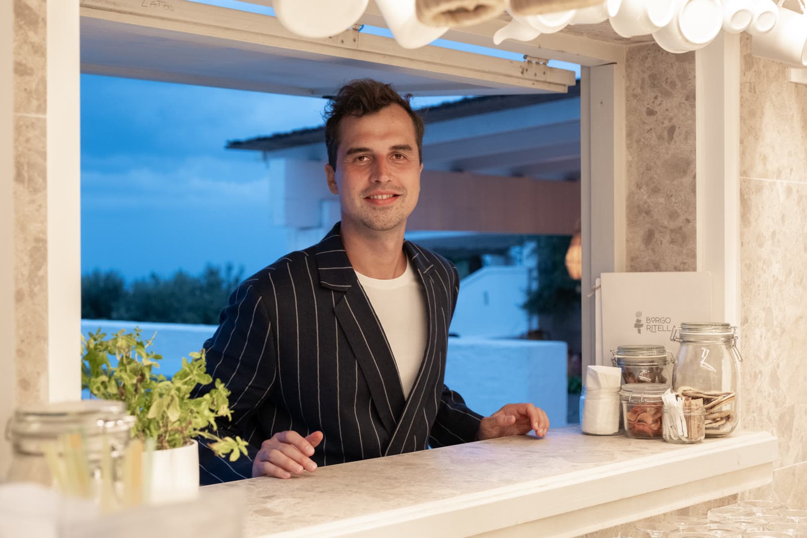 Christian at the pass of a serviced apartment property at dusk.